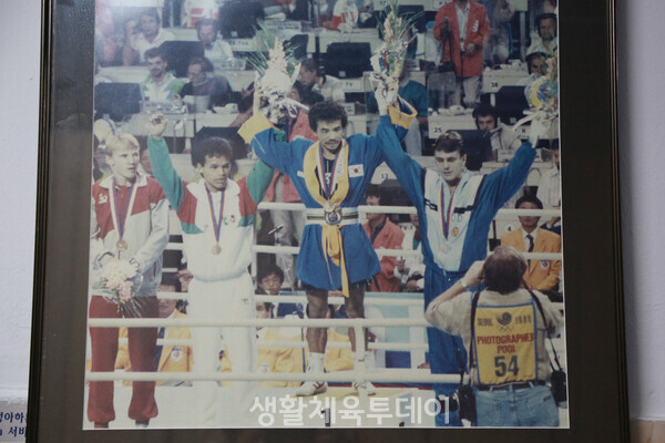 1888 서울 올림픽 플라이급에서 금메달을 획득한 김광선(오른쪽에서 두 번째)이 시상대 맨 위에서 두 팔을 번쩍 치켜들고 기쁨을 만끽하고 있다. 김광선 복싱체육관을 장식한 수많은 기념물 가운데 가장 돋보이는 사진이다 ﻿©홍남현